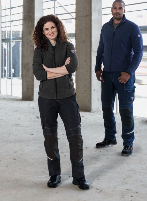 Man and woman standing on a building site wearing BP® fleece jackets.
